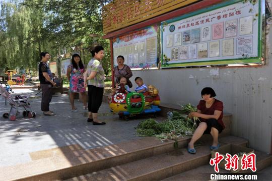 6月15日，鄯善县出现高温天气，蝴蝶泉社区居民在辖区小广场纳凉、聊家常。　肖广梅 摄