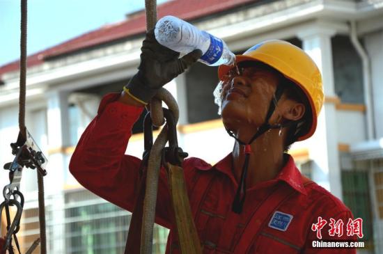 连日来，江西遭遇持续高温天气，多地气温超35摄氏度，在烈日炙烤下，江西德兴市天然气有限公司施工人员冒着酷暑，在户外高处架设天然气管网，让该市首批农村居民使用上天然气。 董世超 摄